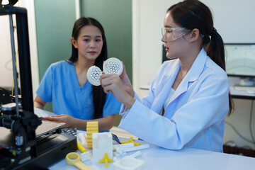 Researchers are working with a 3D printer to print clear, white plastic models using cutting-edge,...