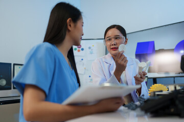 Researchers are working with a 3D printer to print clear, white plastic models using cutting-edge,...