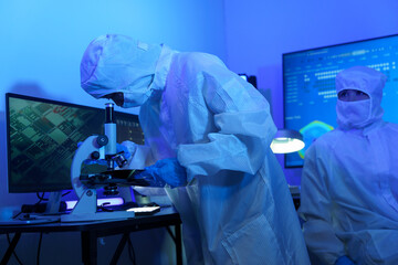 Technician working on analyzing semiconductor or microchip boards, electronics industry, electronic...