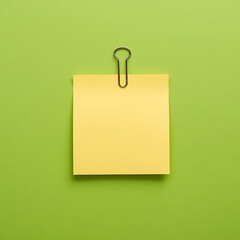 Image of sticky notes paper with a paperclip, set against a green screen background, featuring one sticky note that has empty space.