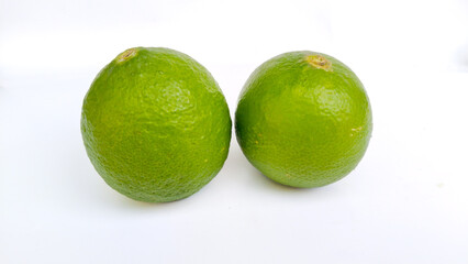 Two fresh green limes on white background, tropical citrus fruit rich in vitamin C and antioxidants