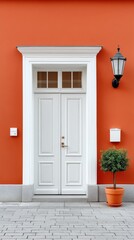 Minimalist White Double Doors Set Within a Vibrant Orange Building Exterior Featuring a Small Green Potted Tree and a Vintage Lamp Accentuating the Entrance