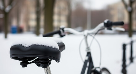 Obraz premium Bicycle in winter scene features seat covered with fresh snow and frame partially visible. Winter bicycle stands unused, inviting thought of colder journeys or warmer weather,