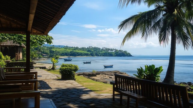 Serene tropical seaside view from a relaxing patio with a wooden bench under a palm tree overlooking a calm bay with fishing boats