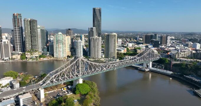 4K aerial push-in tracking motion view of the iconic Story Bridge and east side of Brisbane CBD with Brisbane River below where  CityCat ferries commute passengers, Brisbane, Queensland, Australia