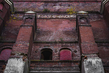 Eine tiefrote, monumentale Backsteinfassade eines alten Industriegebäudes, vermutlich einer Zeche,...