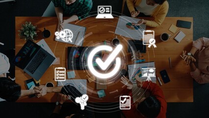 A top-down view of a creative business meeting featuring diverse professionals collaborating around...