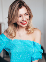 Young beautiful smiling blond female in trendy summer clothes. Carefree woman posing in studio,...