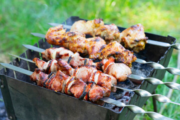 Grilling delicious shashlik on skewers over charcoal at a vibrant outdoor gathering