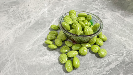 Fresh Green Stink Beans Petai Parkia Speciosa in Glass Bowl on Marble Background – Tropical Asian Ingredient and Exotic Organic Food Concept