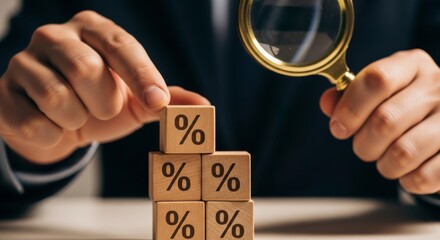 Man holding magnifying glass over wood blocks with percentage signs stacked together