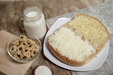 Bread with cheese, sweetened condensed milk, and butter. With white milk and snack on a table for breakfast	
