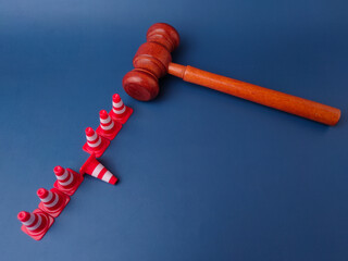 The combination of a gavel and traffic cones can symbolize legal obstacles or the law creating...