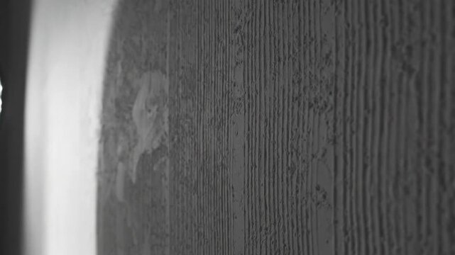 静かなグレーの壁面には細い垂直線が穏やかに走りテクスチャが優しく光る