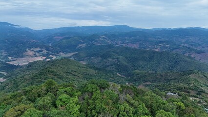Fototapeta premium Green mountain valley landscape in Kunming,Mountains and clouds in Kunming, Yunnan,Natural mountain scenery in Kunming,Kunming valley surrounded by green hills,Misty mountain forest in Kunming