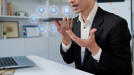 Man using AI voice assistant on smartphone with speech-to-text conversion and chatbot interface, representing smart technology, digital assistant and virtual communication.