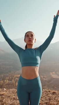 Vertical slow motion close up of mindful woman breathing deeply during morning meditation in mountain light, symbol of focus, peace and presence