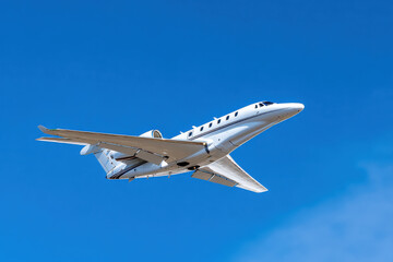 Private jet flying in clear blue