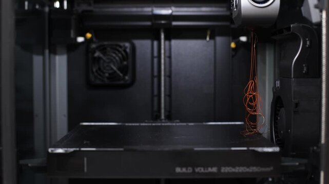 Close-up of tangled filament inside 3D printer, concept of maintenance, error and calibration process.