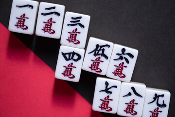 赤と黒の背景に並ぶマージャン牌	