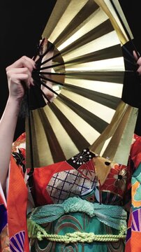 Japanese Geisha In Red Kimono With Golden Fans Performing Ritual Gesture Closing Face Then Turning In Profile Under Studio Light Representing Tradition Symbolism And Inner Strength Of Japanese Art
