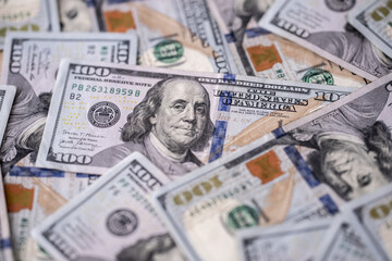 Money background with 100 dollars bills. Texture of US dollars. 100 USD banknotes in focus. American hundred-dollars notes spread on a table. Pattern of US dollars for finance concept.