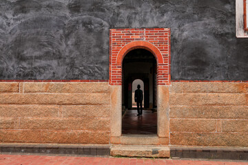 Traditional Chinese temple wall design and entrance. Tourist exploring, silhouette, copy space.
