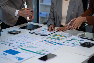 Teamwork process, Business team using a calculator to calculate the numbers of statistic business profits growth rate on documents graph data, desk in the office.
