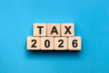 Tax New year 2026 concept. Wooden cubes on a blue background