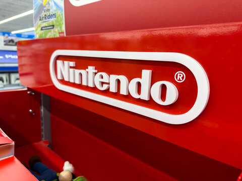 Calgary, Alberta, Canada. Oct 29, 2025. Close-up of a white Nintendo logo mounted on a red retail display shelf in a video game store, editorial retail branding.