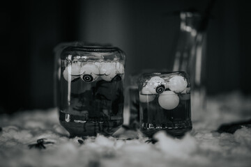 Glass jars filled with floating eyeballs and dark liquid, creating a spooky atmosphere, surrounded...