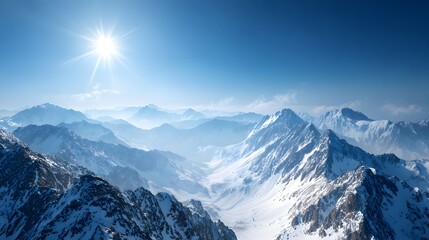 Bright sun shines over vast expanse of snow covered mountain ranges under clear blue sky