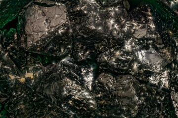 Macro magnetite crystals at 3.7x — black iron mineral with iridescent sheen. Key subject for geology, metallurgy and paleomagnetism