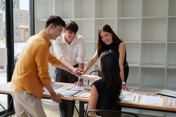 Team members putting hands together collaborating on project planning