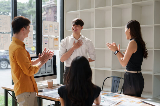 Young team congratulating colleague for success and achievement
