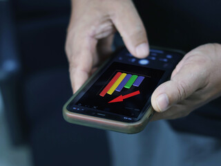 Hand holding a phone showing a business growth graph.