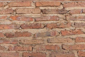 A close up of an old brick wall with an aged texture.