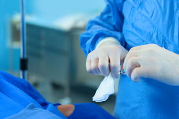 Intravenous injection before surgery. Modern surgery. Real operation. Surgeon's hands are gloved.