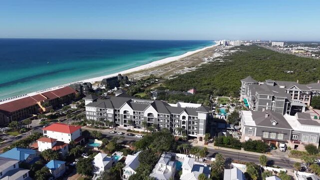 Drone orbit of seaside neighborhood with white sandy beach and houses, apartments in sunny weather, 30A, Florida, USA