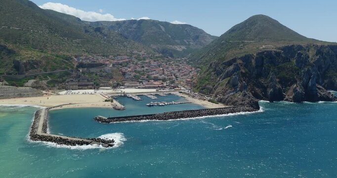 Aerial view of Buggerru Sardegna harbor, vibrant blue sea, rocky coastline