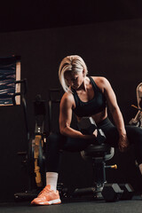 Caucasian fitness woman lifting dumbbells in a gym, focused workout