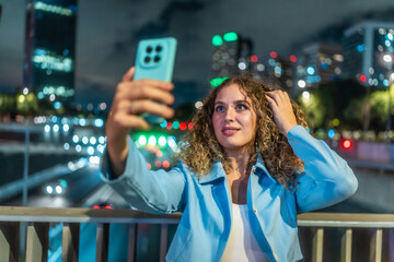 Woman taking selfie using smartphone at night city