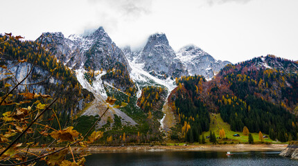 Autumn's First Snow Track Gosausee with Dachstein mountain summit and blue lake as idyllic colorful autumn scenery background