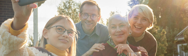 Header of teenage Caucasian girl taking selfie with middle aged Caucasian man, senior Caucasian...