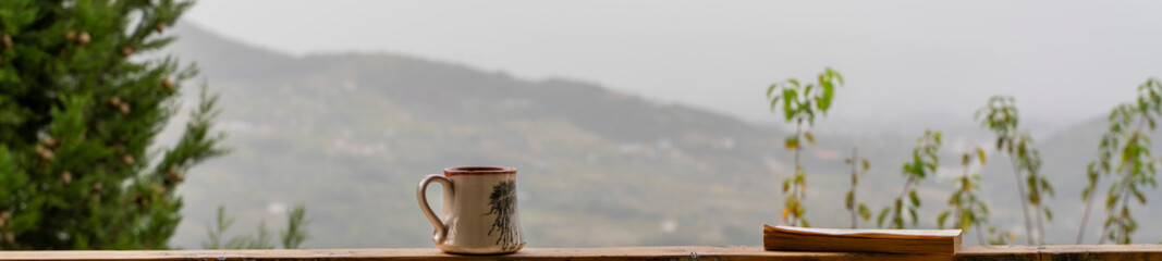 Morning Coffee and Book Reading Against a Misty Mountain View