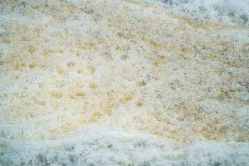 Abstract view of speckled foam bubbles creates a soothing, neutral background. The combination of textures and subtle hues offers a versatile backdrop for a variety of design applications.