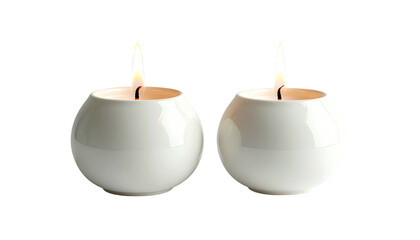 Two round white candles burning brightly in simple ceramic holders