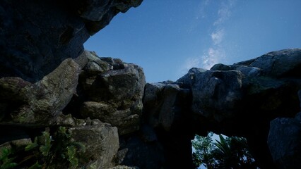Towering stone formations rise majestically towards a brilliant sky. Lush greenery peeks through the rocks, suggesting a serene natural oasis waiting to be explored.