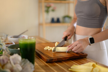 Closeup of young female hands chopping banana