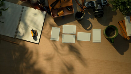 Creative workspace with vintage camera, notebook, and coffee cup in warm morning sunlight